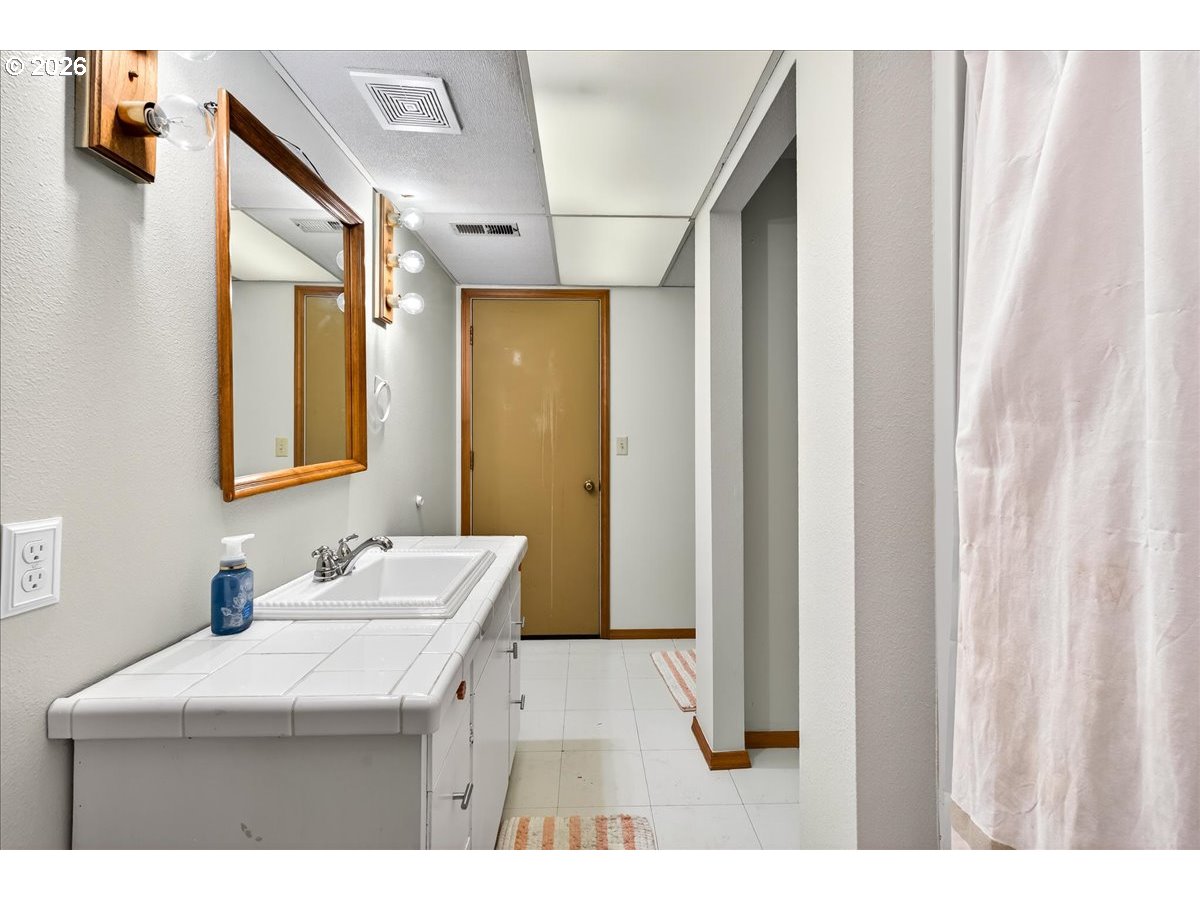 29009 Southwest Burkhalter Road Hillsboro, OR 97123 - Photo 26 of 48 a bathroom with a sink a mirror and a shower