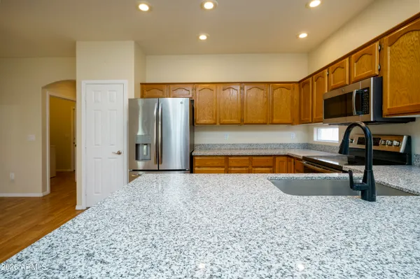 a living room with stainless steel appliances wooden floor and a couch