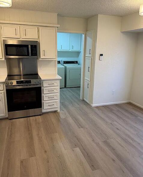 5232 95th Street Lubbock, TX 79424 - Photo 14 of 35 a kitchen with wooden floors and stainless steel appliances