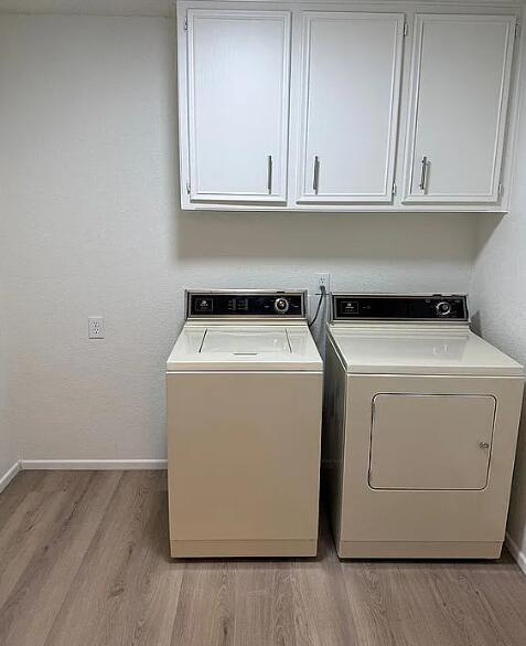 5232 95th Street Lubbock, TX 79424 - Photo 17 of 35 a utility room with wooden floor washer dryer and cabinets