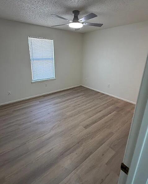 5232 95th Street Lubbock, TX 79424 - Photo 24 of 35 an empty room with wooden floor chandelier fan and windows
