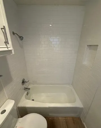 a bath tub sitting next to a white toilet and sink