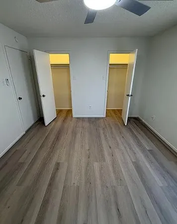 an empty room with wooden floor and closet