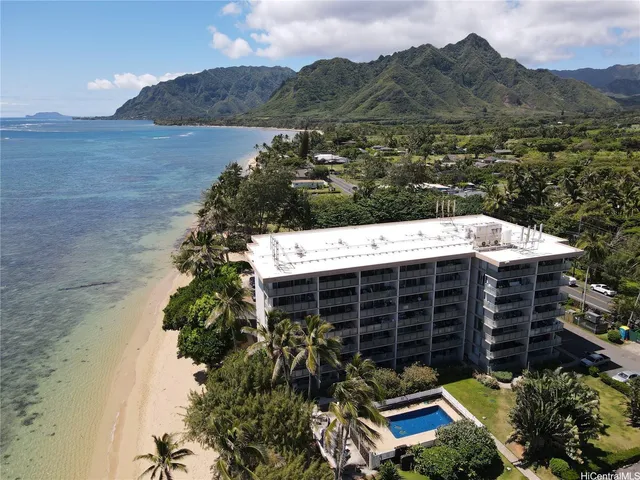 an aerial view of a house with a yard and a large tree