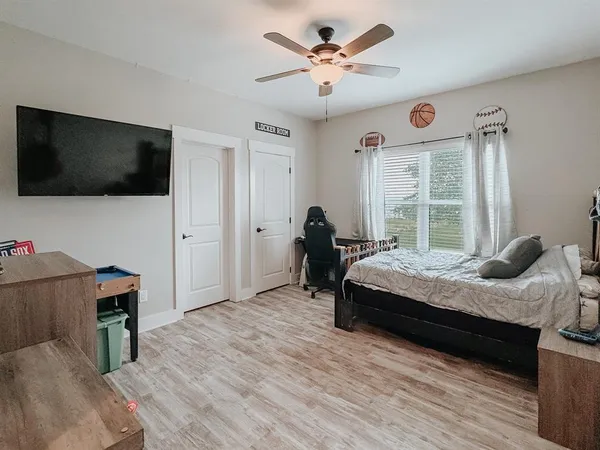 a spacious bedroom with a bed and a flat screen tv