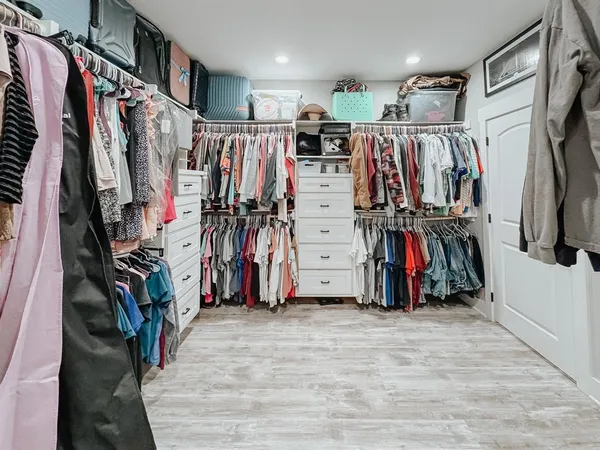 a view of walk in closet with clothes