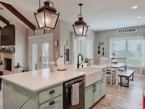 a kitchen with stainless steel appliances a sink a chandelier and living room view