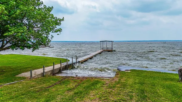 a view of a backyard with plants and lake view