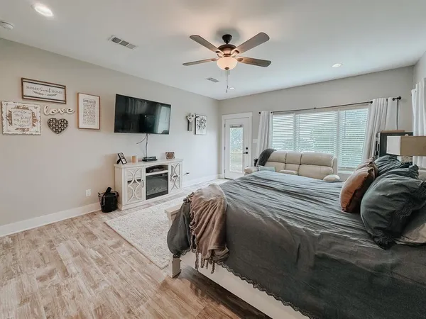 a bedroom with a bed a window and a flat screen tv