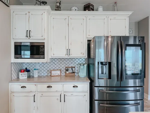 a kitchen with appliances a refrigerator and cabinets