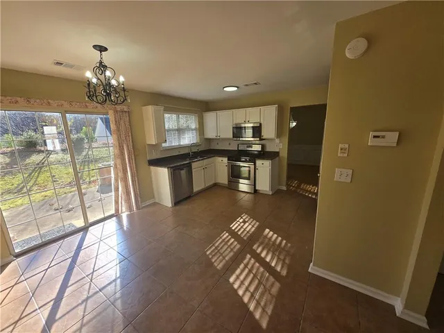 a kitchen with stainless steel appliances granite countertop a refrigerator sink and stove