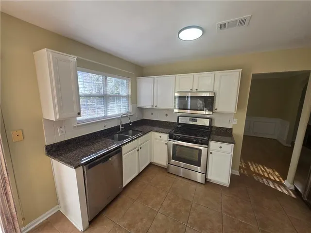 a kitchen with refrigerator and microwave