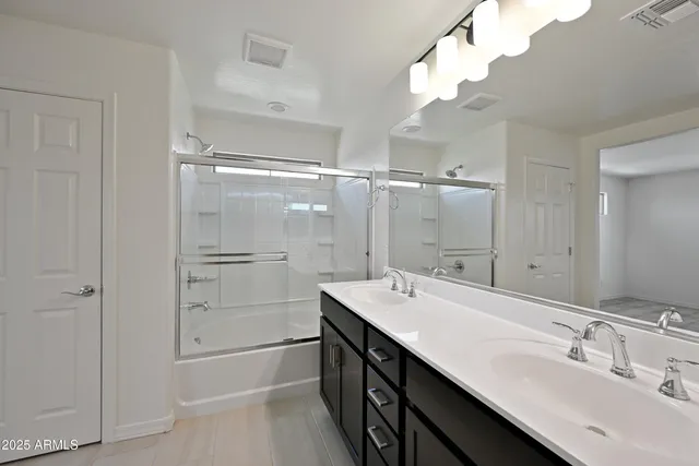 a spacious bathroom with a bathtub shower sink mirror and toilet