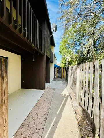 a view of backyard with large trees and wooden fence