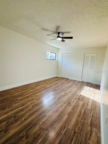 a view of empty room with wooden floor