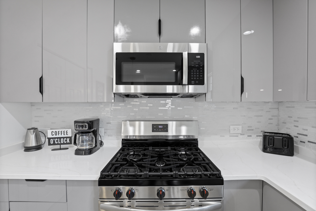 7125 Simpson Street Morton Grove, IL 60053 - Photo 11 of 33 a kitchen with kitchen island granite countertop a stove a sink a microwave and cabinets
