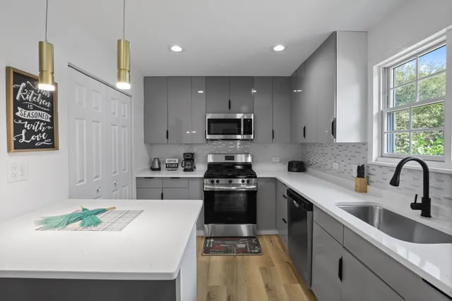 a kitchen with a sink a stove and cabinets