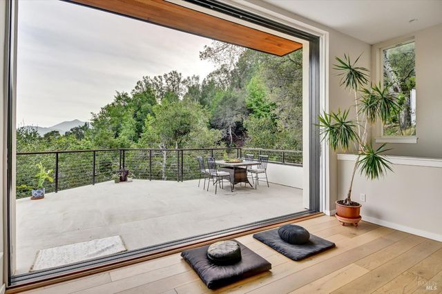 a view of a balcony with chairs potted plants and wooden floor