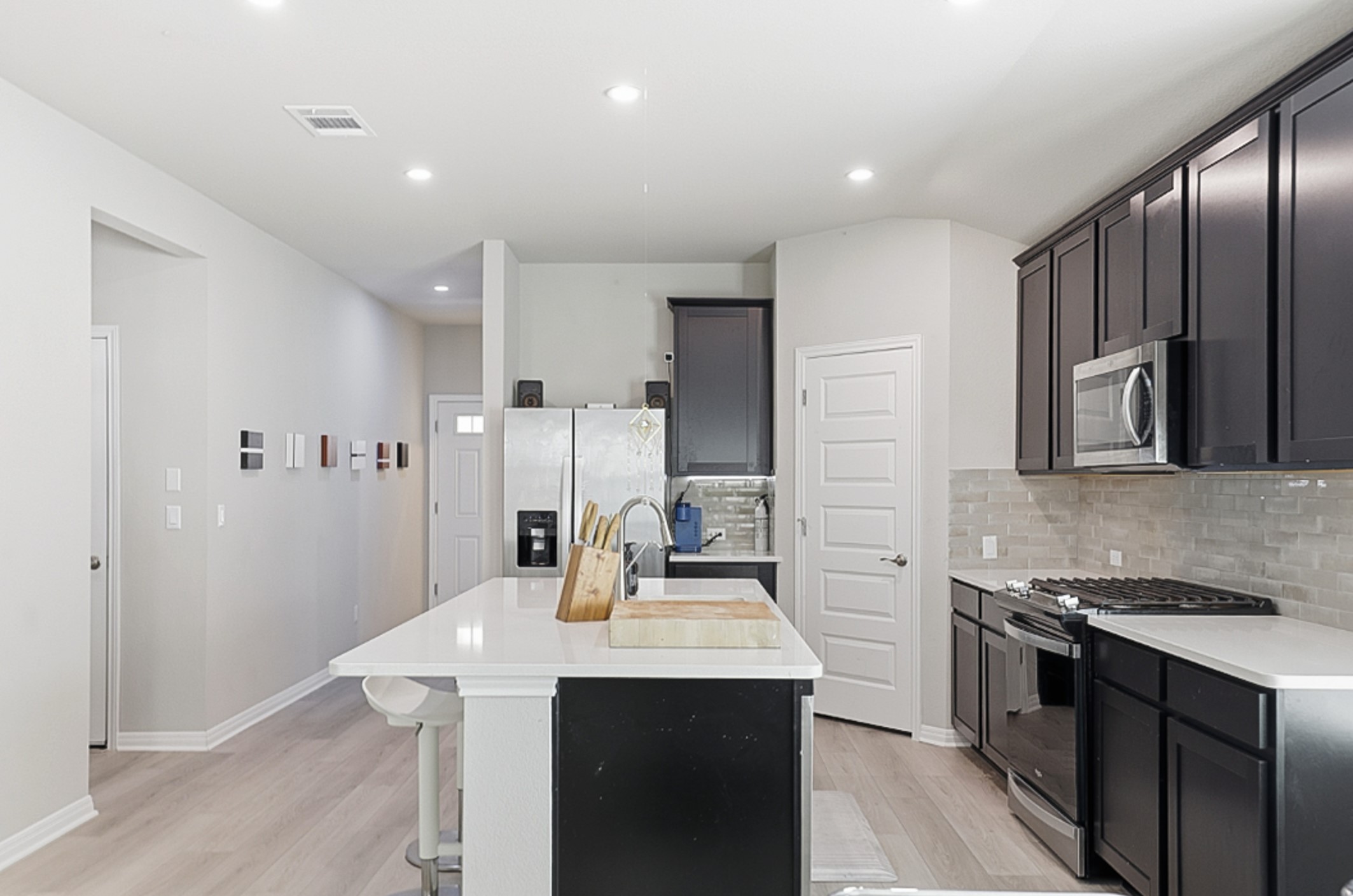 12206 Purple Prairie Lane Buda, TX 78610 - Photo 4 of 24 Rich espresso cabinetry adds a touch of elegance that anchors the homes bright design.