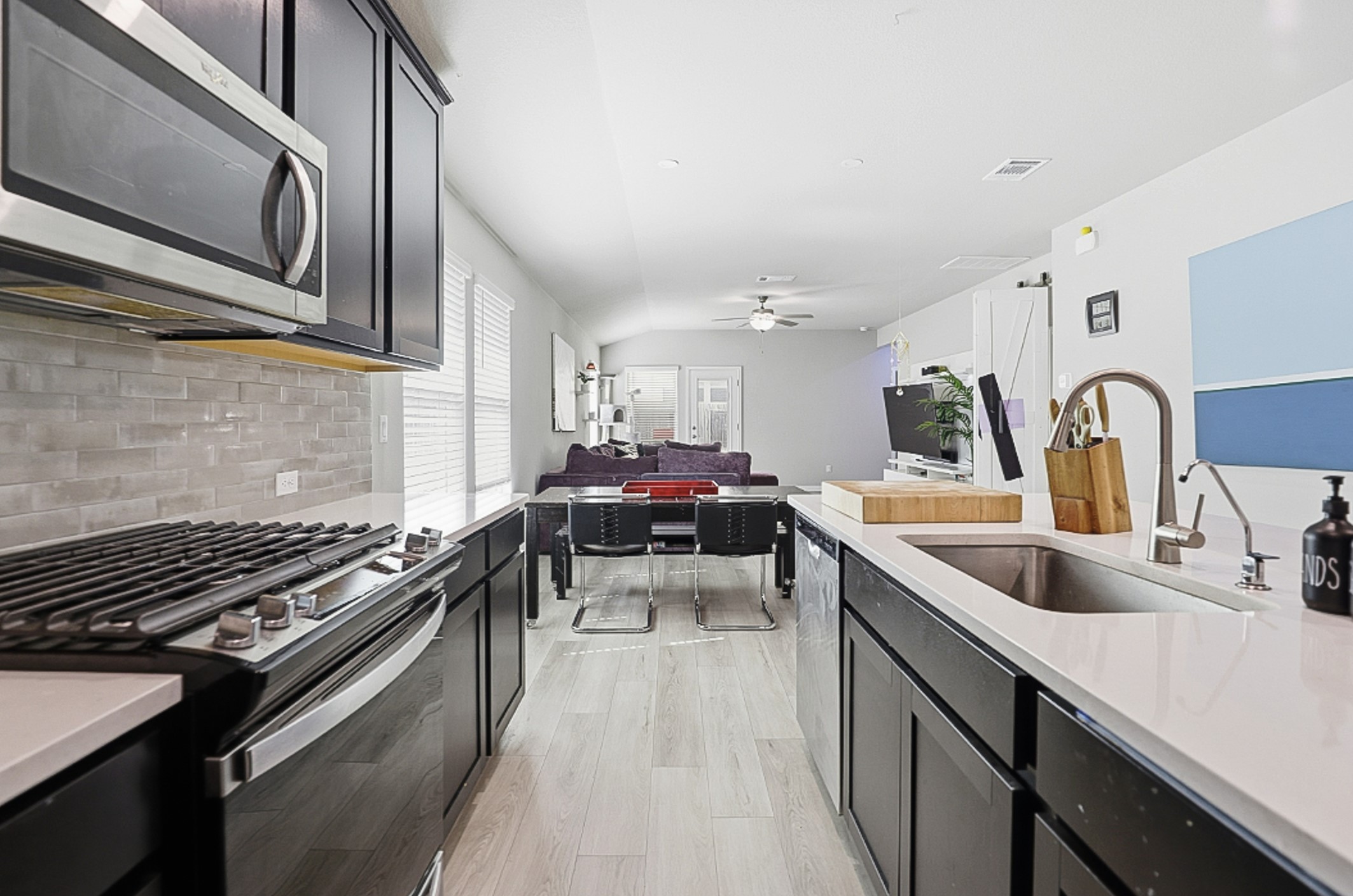 12206 Purple Prairie Lane Buda, TX 78610 - Photo 5 of 24 Chic tile backsplash and quartz countertops bring a modern touch to the kitchen.