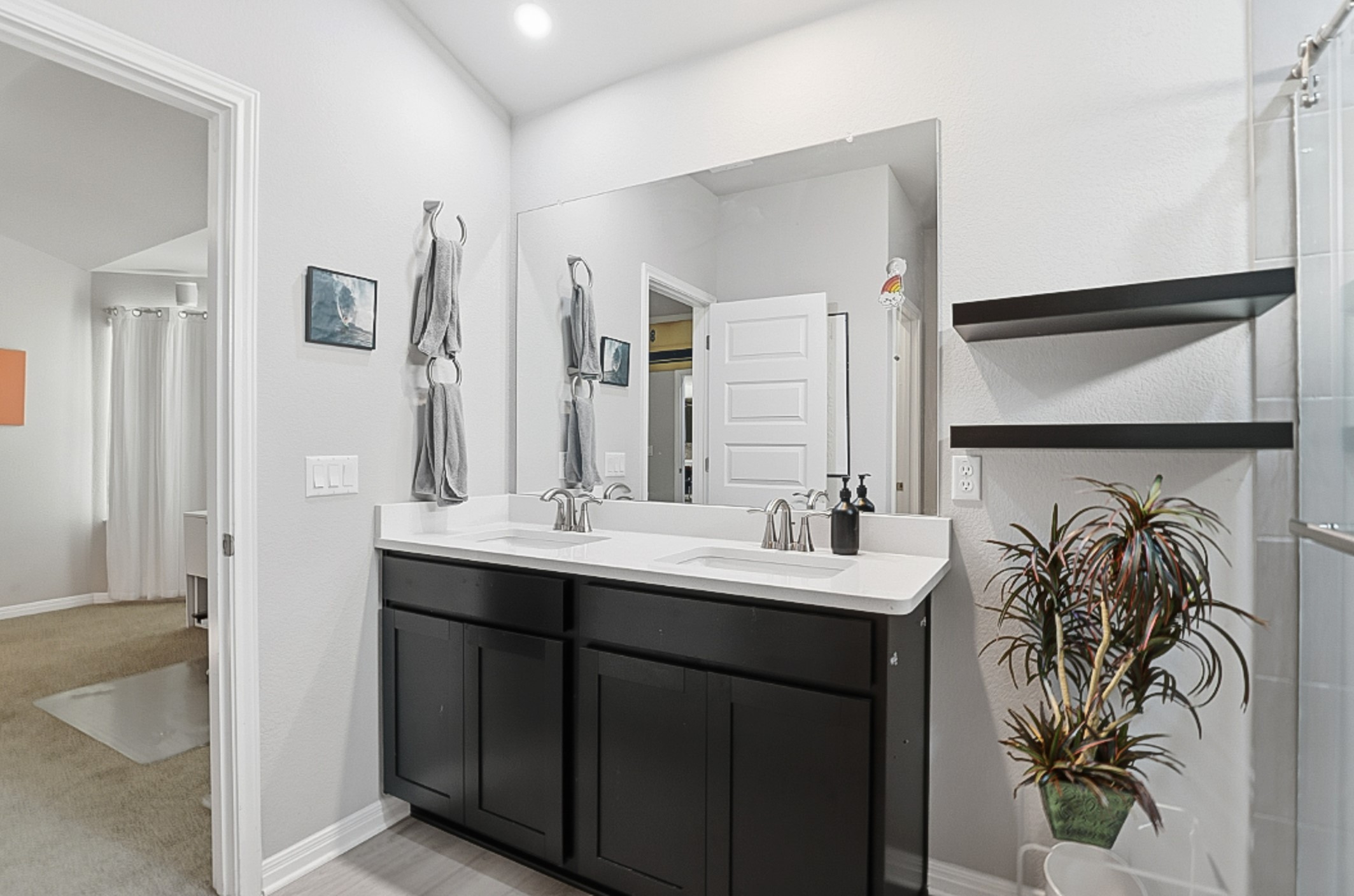 12206 Purple Prairie Lane Buda, TX 78610 - Photo 10 of 24 The primary ensuite features a dual vanity and floating shelves.
