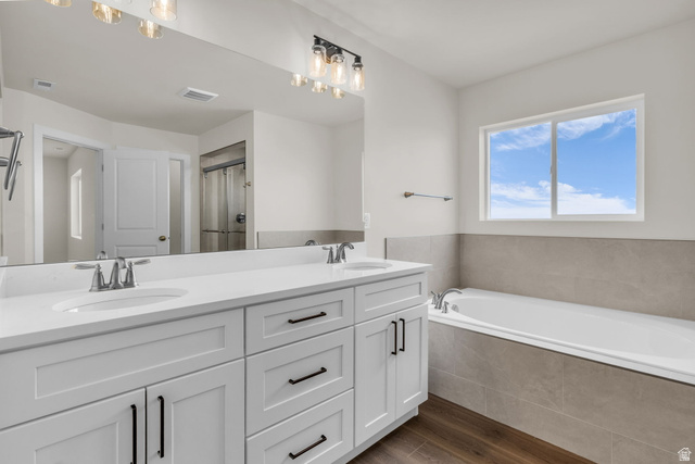 576 7th Avenue Midvale, UT 84047 - Photo 15 of 32 Bathroom featuring dark wood-type flooring, double vanity, a garden tub, and a shower with curtain
