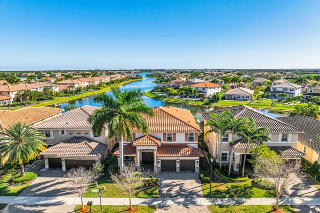 an aerial view of residential houses with outdoor space and ocean view