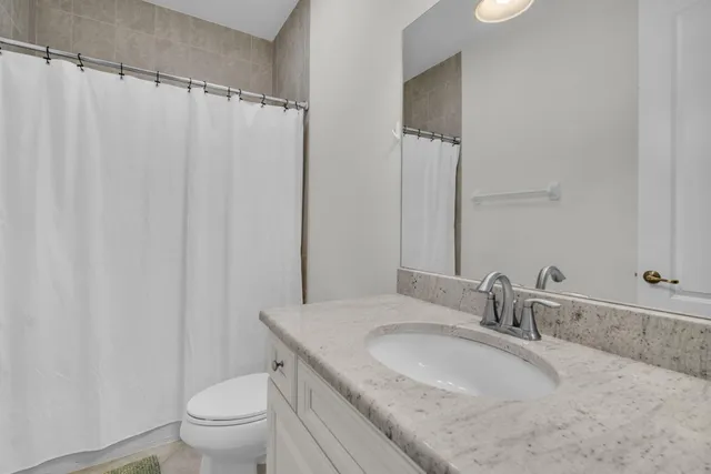 an aerial view of a city with lots of residential buildings ocean and mountain view in back