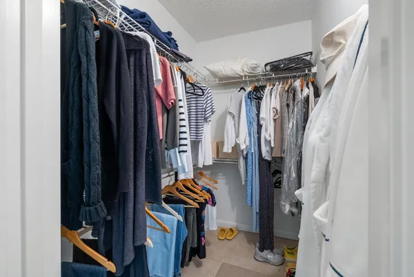 a view of walk in closet with clothes and shoes