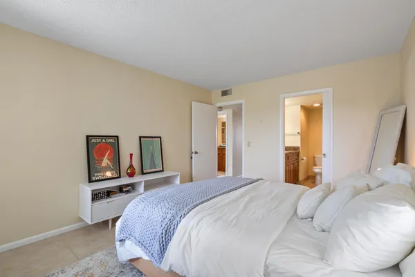 a bedroom with a bed and a painting on the wall