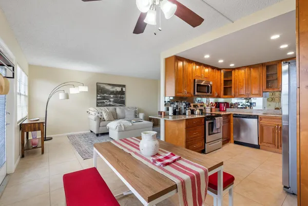 a living room with stainless steel appliances kitchen island granite countertop furniture and a large window