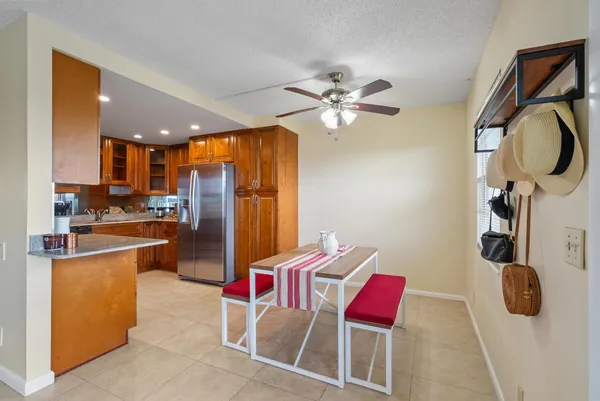 a kitchen with stainless steel appliances kitchen island granite countertop a table chairs in it and wooden floors