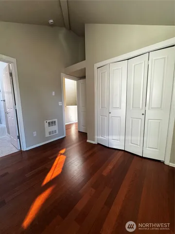 a view of an empty room with wooden floor