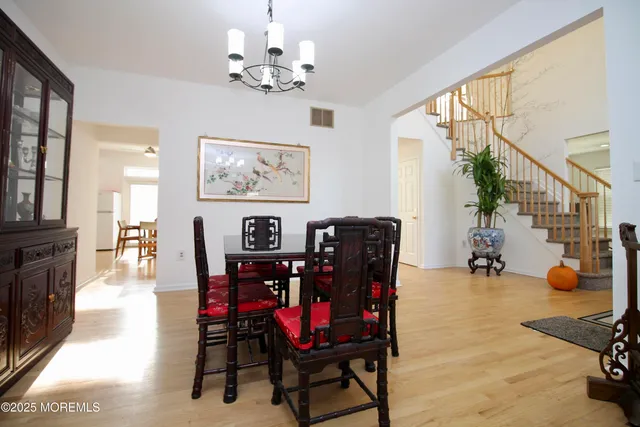 a kitchen with stainless steel appliances a dining table chairs refrigerator and microwave