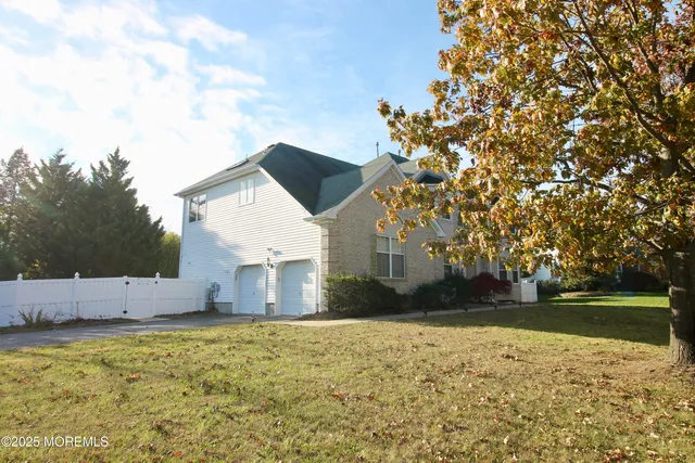 a view of a house with a yard and tree