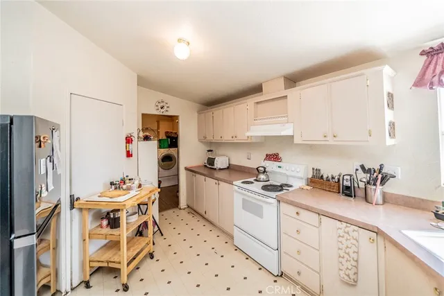 a kitchen with stainless steel appliances a refrigerator sink and cabinets