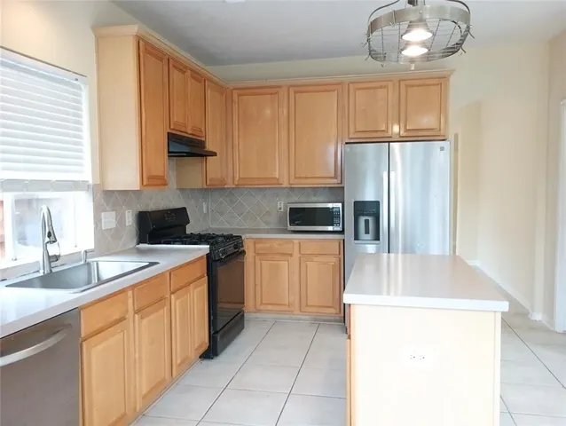 a kitchen with a sink cabinets and refrigerator