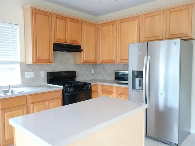 a kitchen with stainless steel appliances granite countertop a refrigerator sink and cabinets