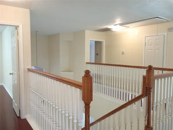 a view of a hallway with wooden floor and stairs