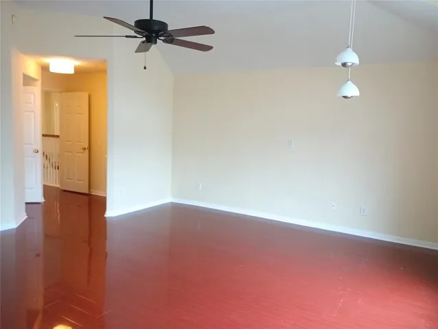 a view of a room with wooden floor and a ceiling fan