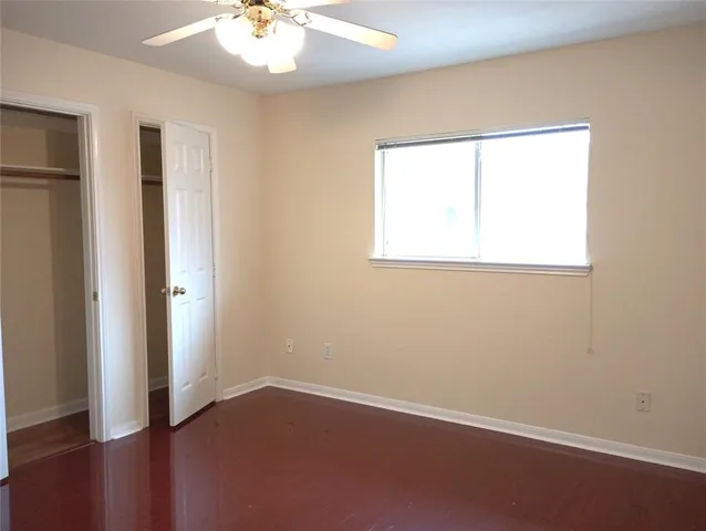 an empty room with a window and a ceiling fan