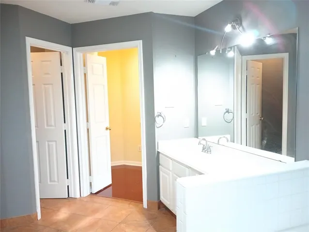 a bathroom with a tub sink and mirror