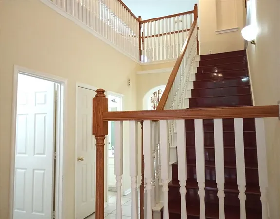 a view of staircase with lots of frames on wall and a window