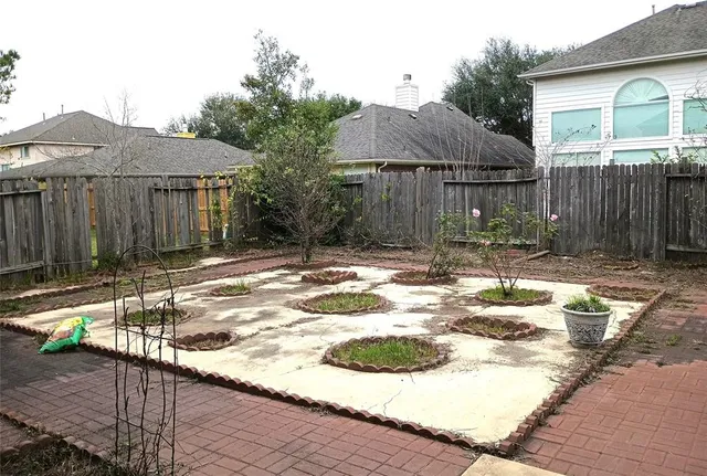 a backyard of a house with barbeque oven table and chairs