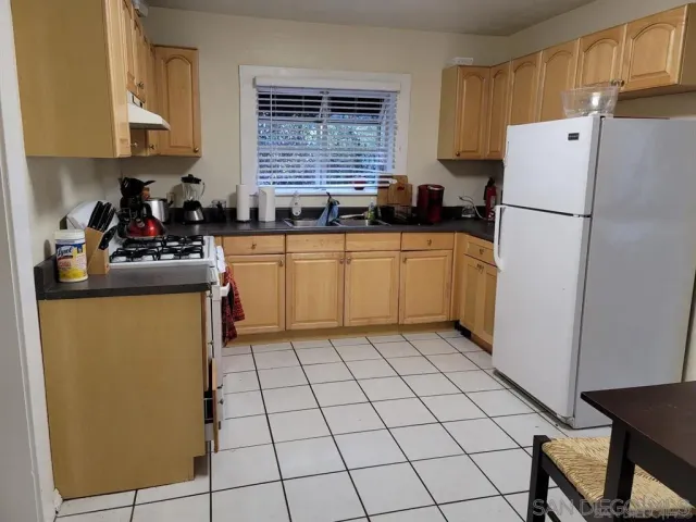 a kitchen with a refrigerator sink stove and cabinets