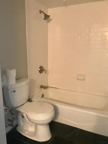 a bathroom with a toilet and a shower