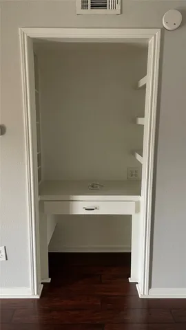 a view of walk in closet with wooden floor