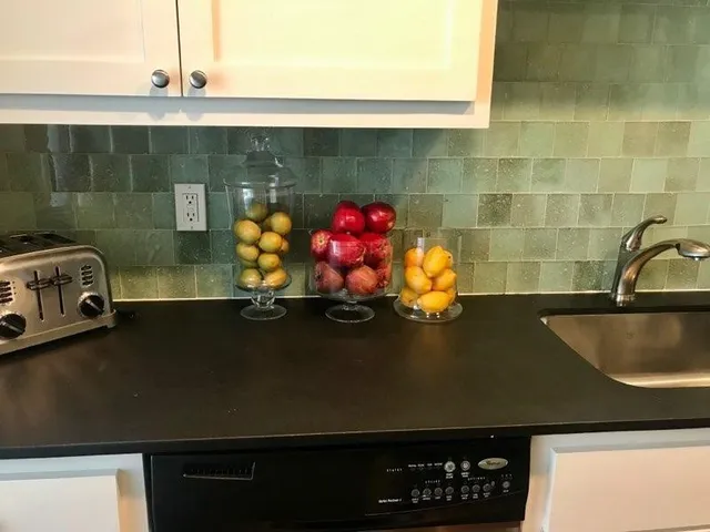 a close view of sink a faucet and a stove