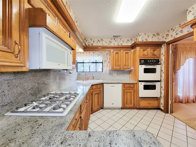 a kitchen with a stove a sink and a microwave