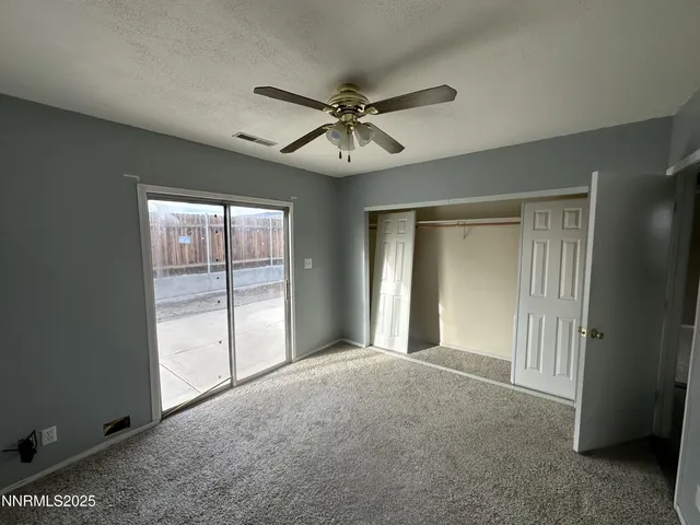 a view of a livingroom with a ceiling fan and window